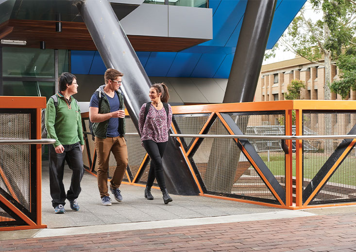 Three La Trobe University students walking out of a building.